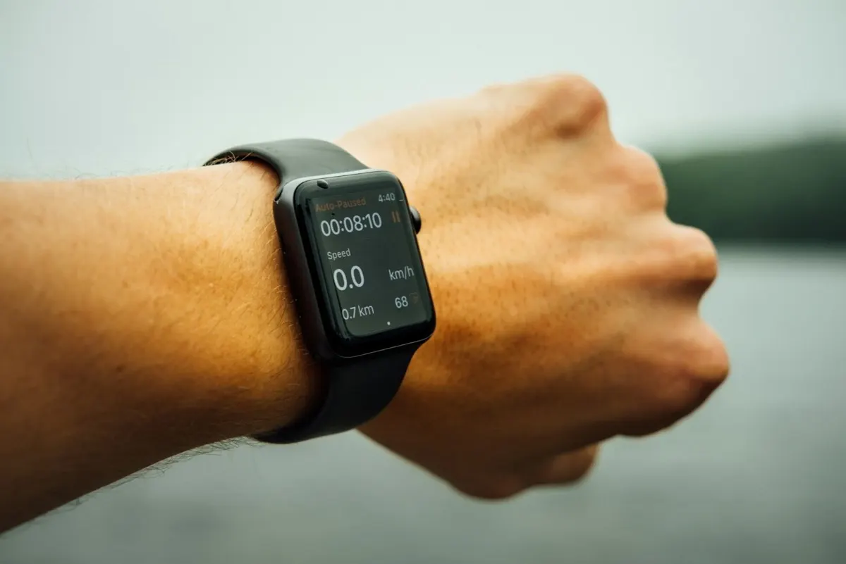 Runner checking an Apple Watch during an interval workout