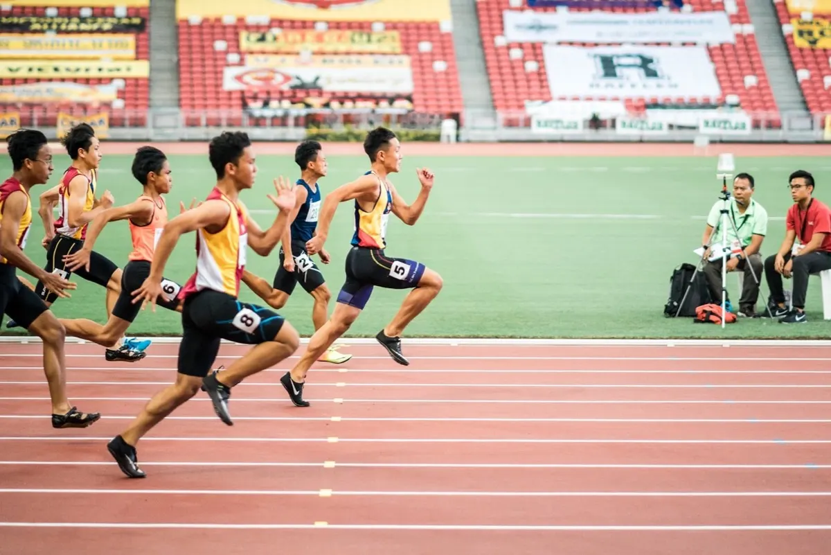 Athletes running a 20 meter shuttle test across a sports hall