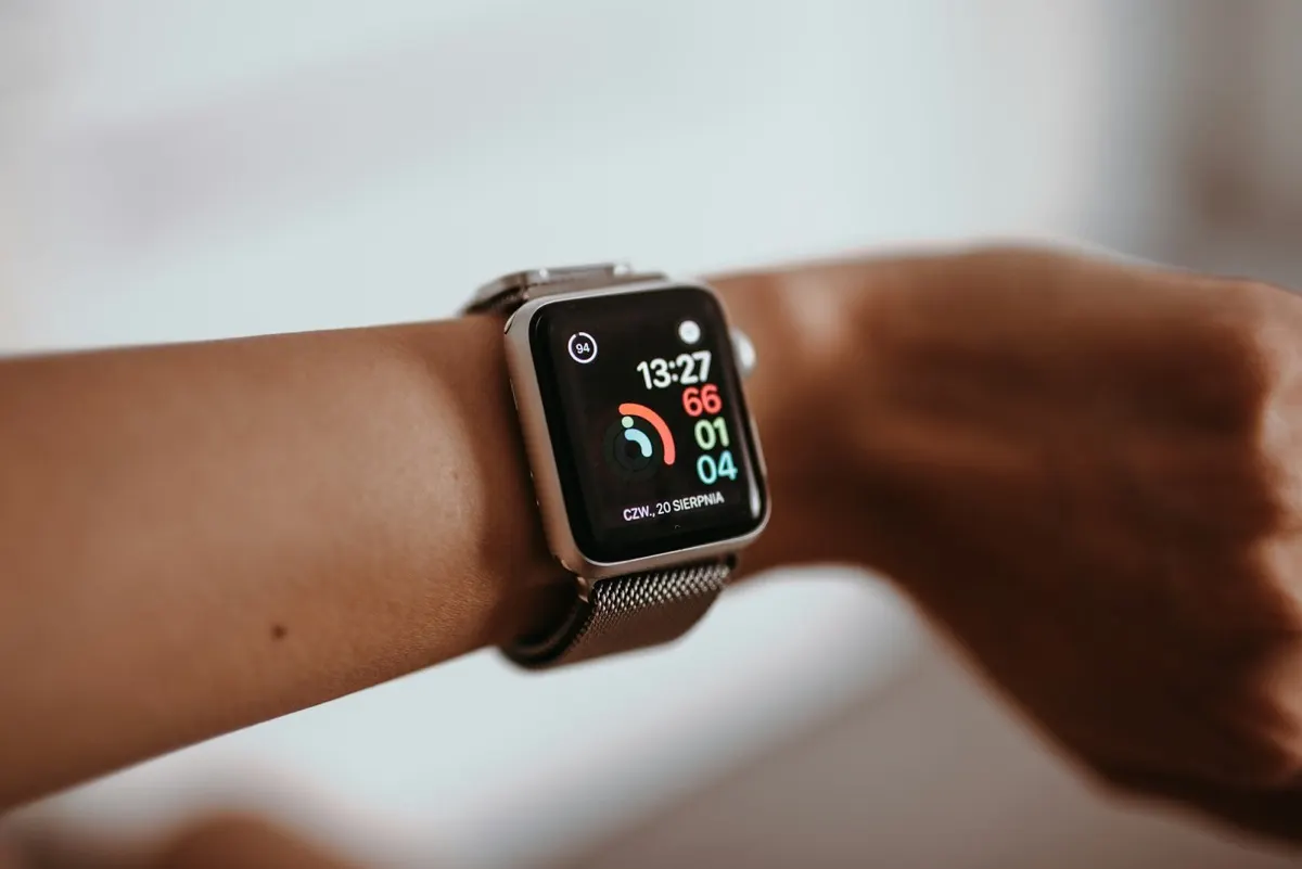 Runner looking at a fitness app on a phone and smartwatch