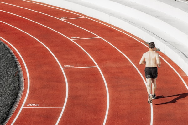 Runner sprinting on a red athletic track
